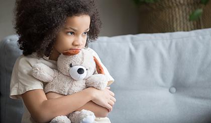 sad child hugging a teddy bear